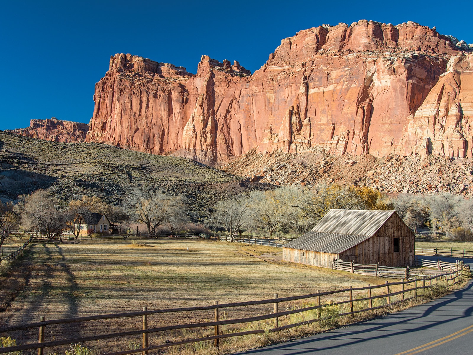 Wingate Sandstone cliffs behind historic barn and farmhouse