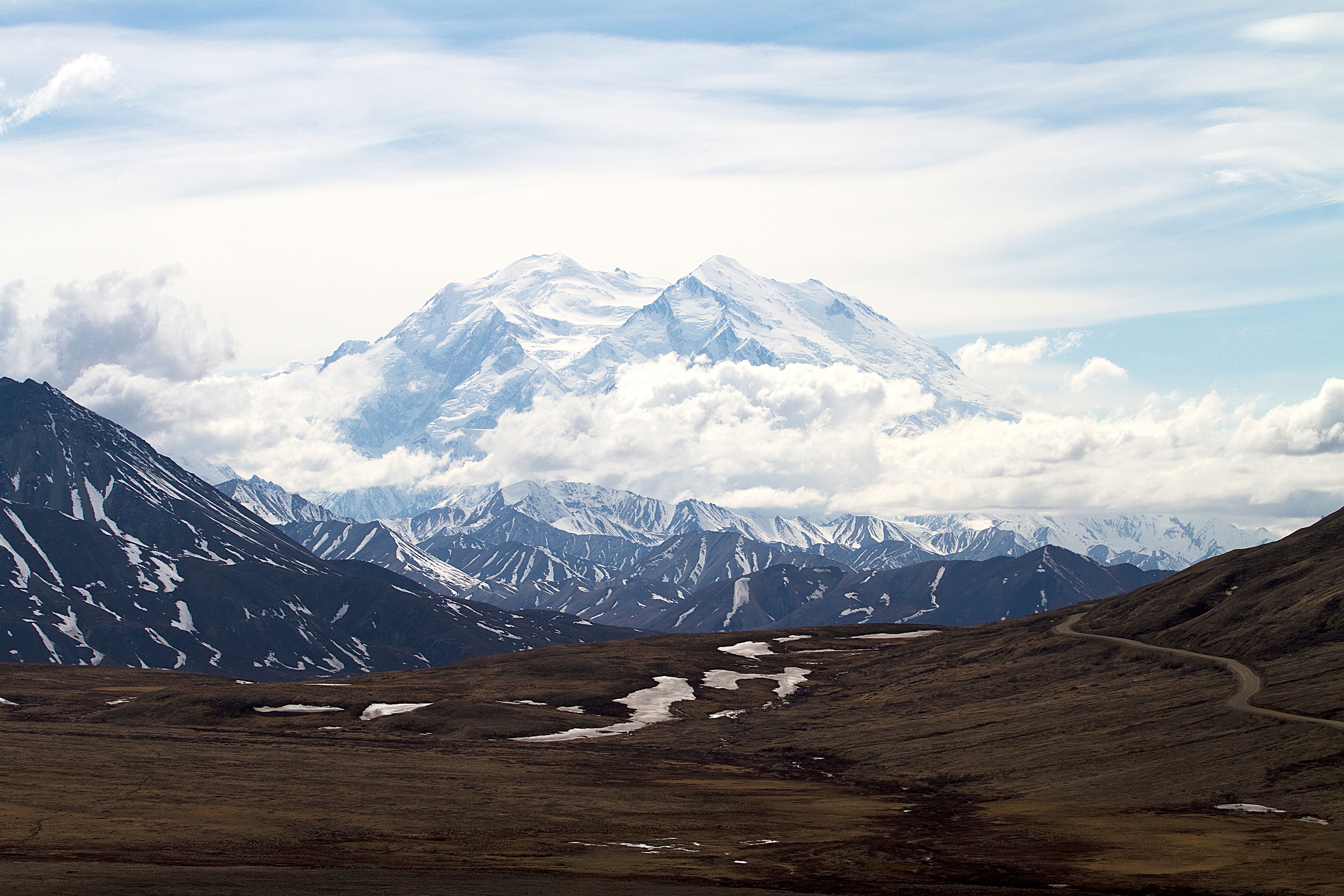 a vast white mountain looming over a brown landscape